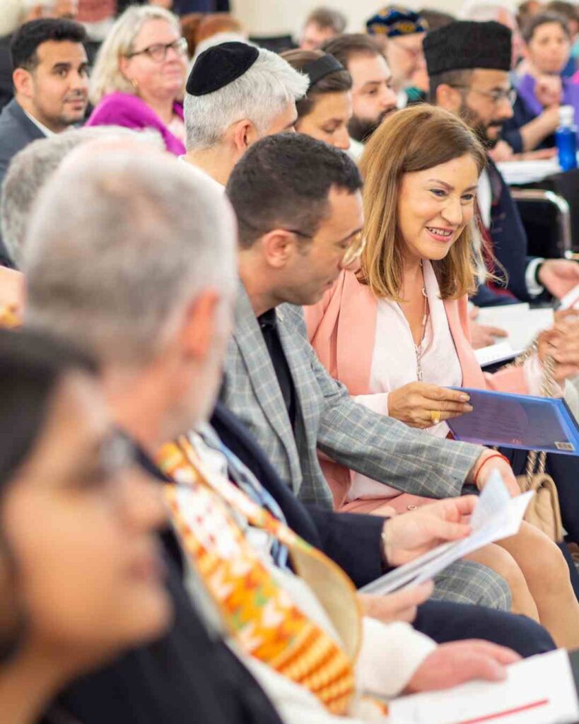 Gäste im Publikum einer multireligiösen Veranstaltung