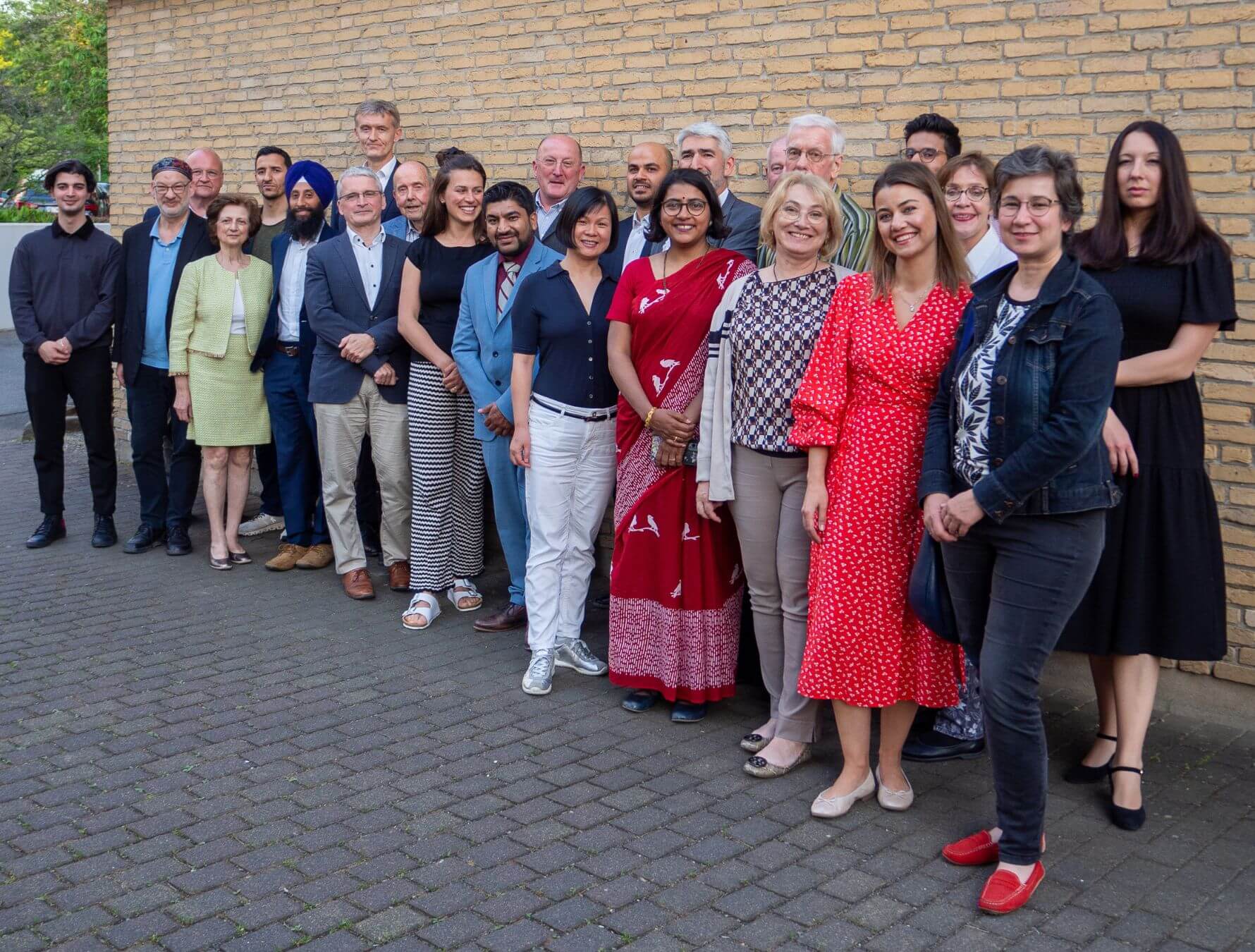 Gruppenfoto der Mitglieder des Rats der Religionen Frankfurt vor einer Backsteinwand