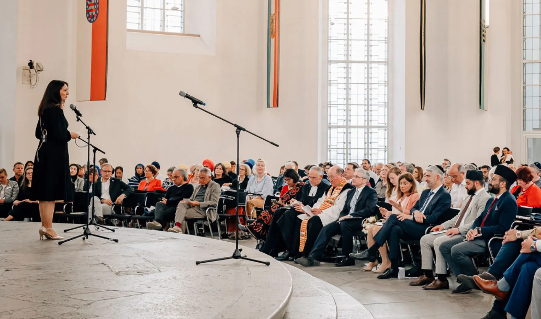 Rednerin vor Publikum bei der multireligiösen Feier in der Frankfurter Paulskirche