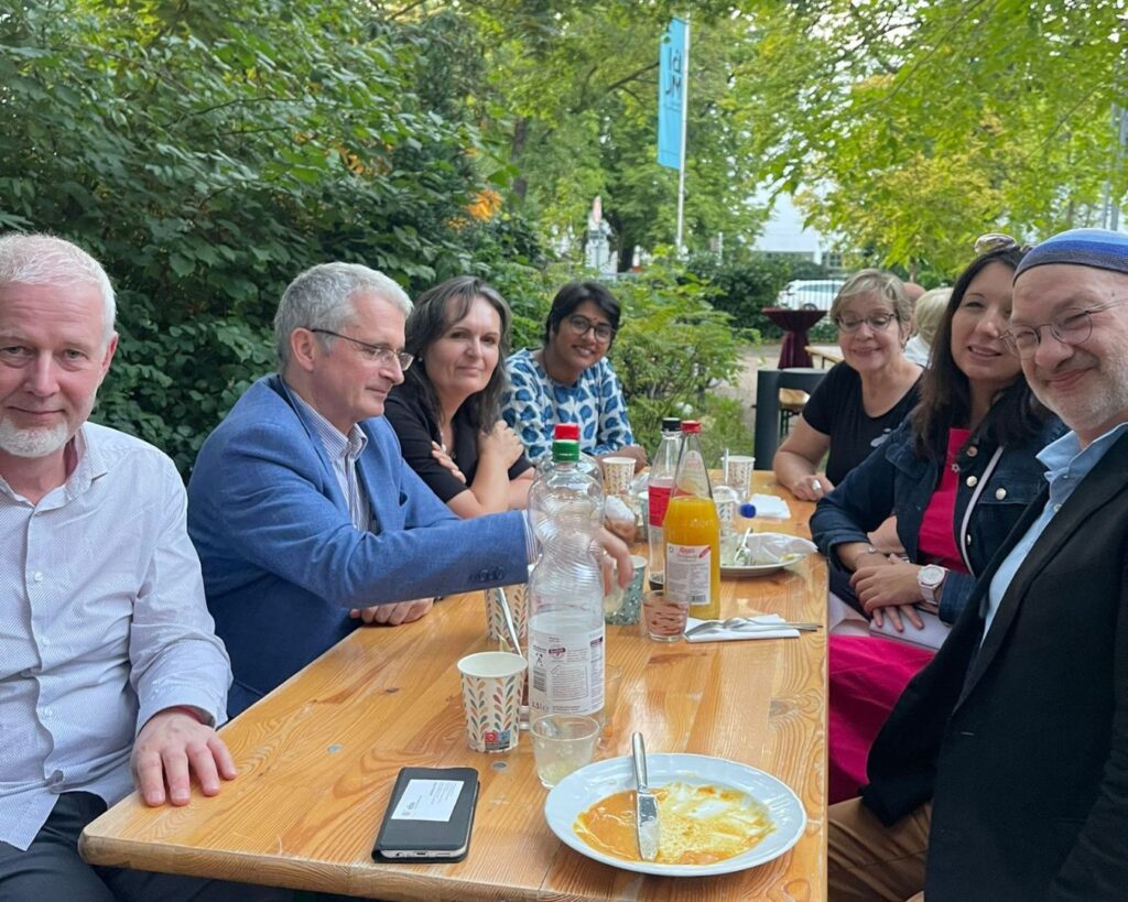 Gäste des Sommerfests an einem Tisch im Garten