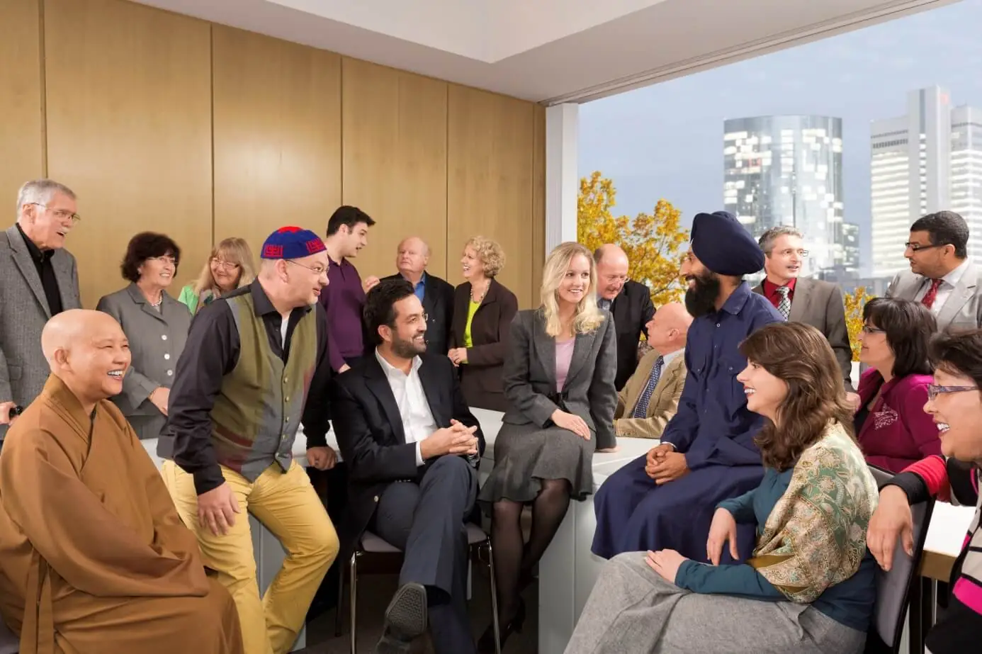 Mitglieder verschiedener Religionsgemeinschaften im Gespräch, im Hintergrund die Frankfurter Skyline